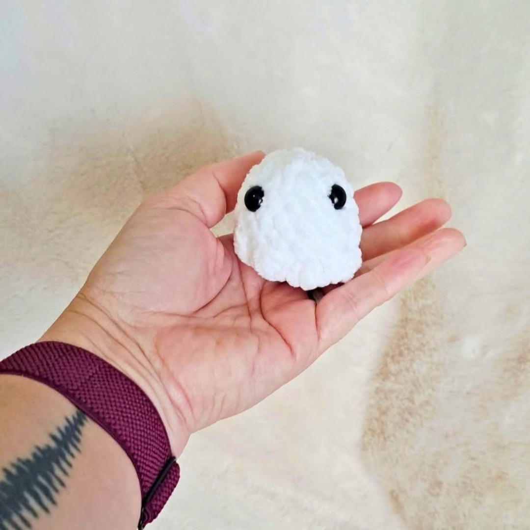Tiny handmade crochet ghost plush with big black eyes by Chai Rose Crafts, palm-sized spooky desk buddy